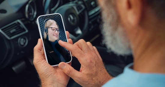 
						  Mann sitzt im Mercedes-Benz Fahrzeug und f�hrt ein Videogespr�ch mit einer Beraterin �ber sein Smartphone.
						  