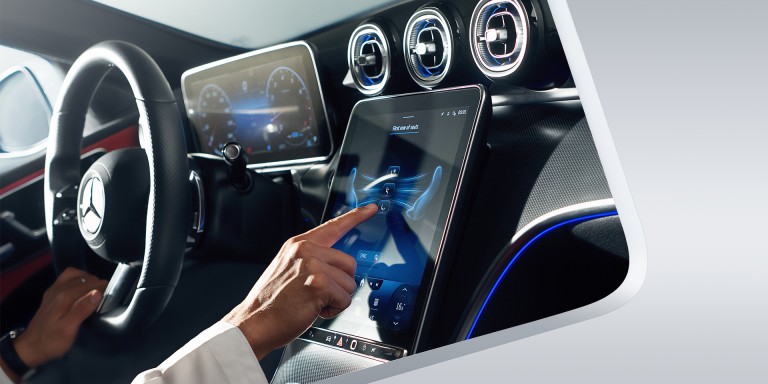 
							Hand bedient den gro�en Touchscreen im Mercedes-Benz Cockpit, digitale Anzeigen und L�ftungsd�sen mit blauer Ambientebeleuchtung sorgen f�r Komfort und Sicherheit.
					 	 
