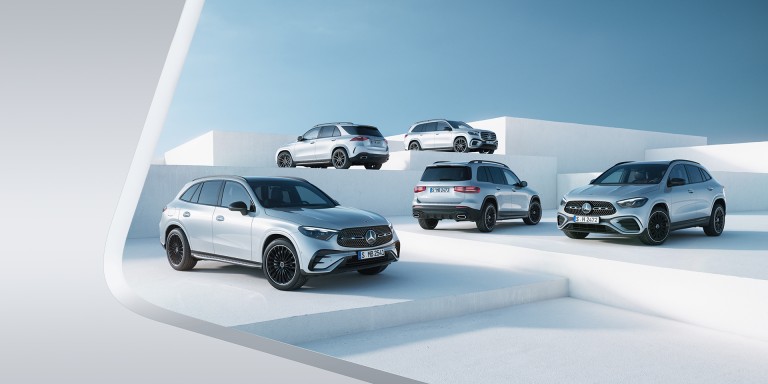 
							F�nf silberne Mercedes-Benz SUVs stehen auf gestuften, wei�en Plattformen vor blauem Himmel in einem modernen Studio-Setting.
					 	 