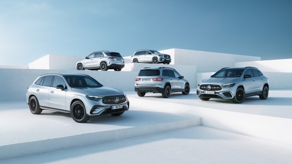 
					  		F�nf silberne Mercedes-Benz SUVs stehen auf gestuften, wei�en Plattformen vor blauem Himmel in einem modernen Studio-Setting.
					  		