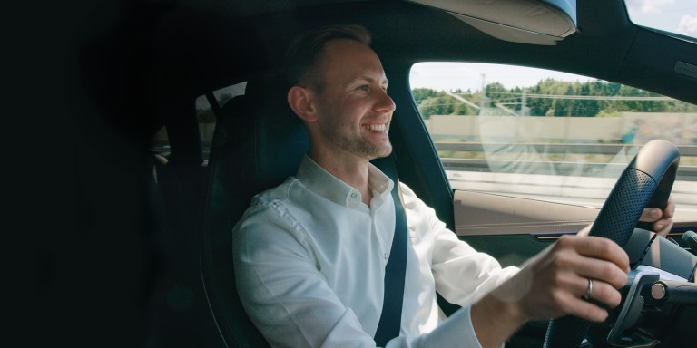 
							Mercedes-Benz Members Produkttrainer Christoph Geissler sitzt am Steuer seines Fahrzeugs und schaut uns an.
					 	 