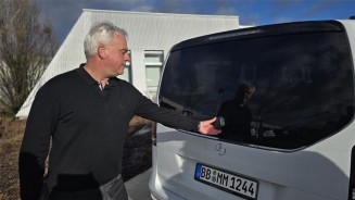 
Mercedes-Benz Members Verkufer Martin Umrath steht an der geschlossenen Heckklappe seiner V-Klasse.
