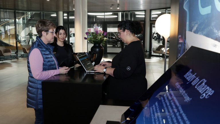 
			Julia Lbbehusen steht mit Fahrzeugbergeberin Dilara Aydin (M.) am Informationsschalter, wo eine Mitarbeiterin ihre Bestellung heraussucht.
		