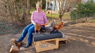 
Julia Lbbehusen sitzt auf einem Hhnerhaus in ihrem Garten und fttert ihre vier Hhner.

