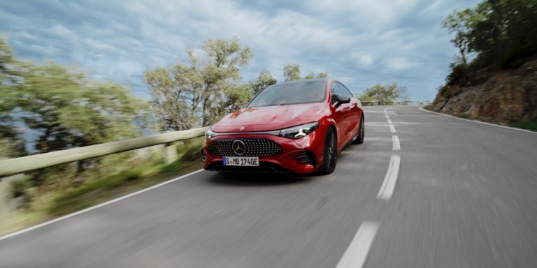 
				Vorderansicht des neuen CLA mit EQ-Technologie von Mercedes-Benz in MANUFAKTUR patagonienrot metallic auf einer Landstrae fahrend.
				