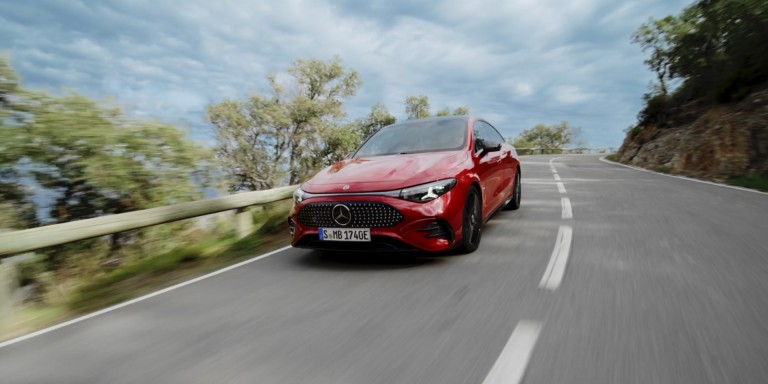 
							Vorderansicht des neuen CLA mit EQ-Technologie von Mercedes-Benz in MANUFAKTUR patagonienrot metallic auf einer Landstra�e fahrend.
					 	 