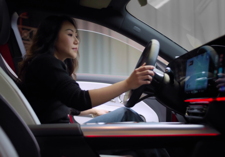 
			  	Frau sitzt am Steuer eines Mercedes-Benz CLA, moderne Innenausstattung mit digitalem Cockpit und roter Ambientebeleuchtung.
			  