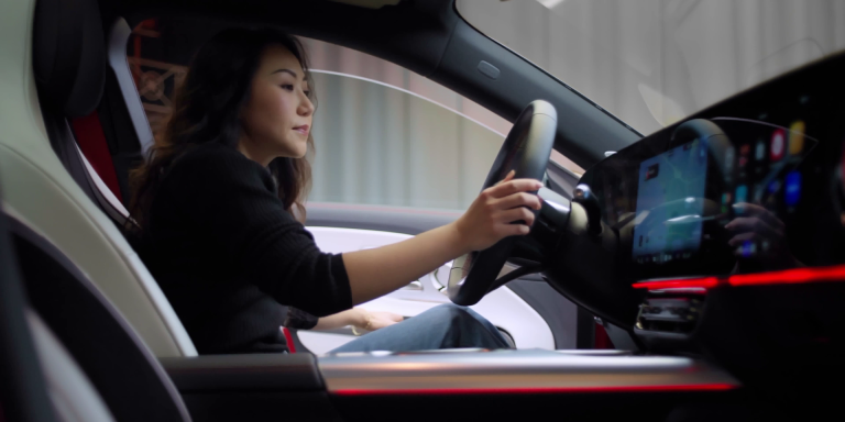 
							Frau sitzt am Steuer eines Mercedes-Benz CLA, moderne Innenausstattung mit digitalem Cockpit und roter Ambientebeleuchtung.
					 	 