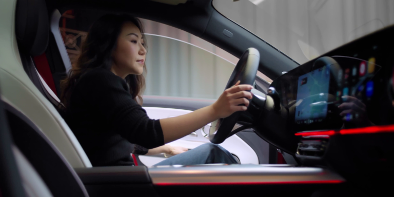 
							Frau sitzt am Steuer eines Mercedes-Benz CLA, moderne Innenausstattung mit digitalem Cockpit und roter Ambientebeleuchtung.
					 	 