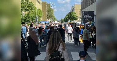 
						  Zahlreiche Menschen besuchen das Werk Dsseldorf, im Hintergrund ist ein groer Mercedes-Benz Stern zu sehen.
						  
