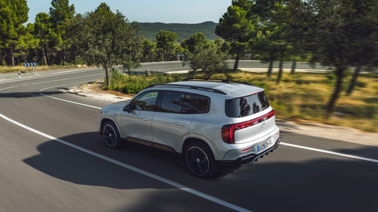 
			Der neue GLB in Hightechsilber f�hrt auf einer kurvigen Landstra�e. Das Fahrzeug ist aus einer leicht schr�gen Heckperspektive zu sehen. Entlang der Stra�e stehen zahlreiche B�umen.
		