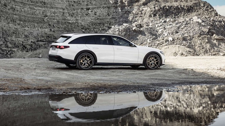 
			Ein weies Mercedes-Benz E-Klasse T-Modell All-Terrain steht in einem Steinbruch neben einer Wasseroberflche, in der sich das Fahrzeug spiegelt.
		