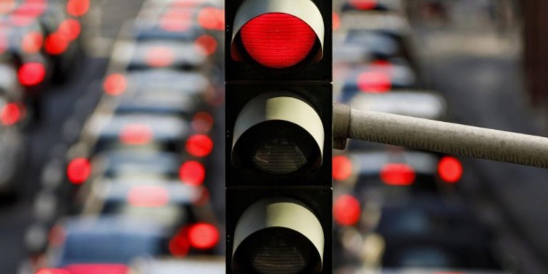 
				Im dichten Straenverkehr leuchtet eine Ampel rot auf.
				