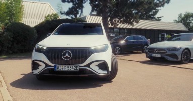 
						  Frontalansicht eines weien EQE SUV mit eingeschlagenen Vorderrdern, der gerade rckwrts auf einem Parkplatz eingeparkt wird. Im Hintergrund stehen zwei weitere Mercedes-Benz Fahrzeuge.
						  