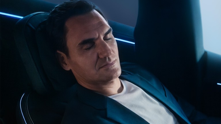 
			Roger Federer sitzt mit geneigter Lehne auf dem Fahrersitz eines Fahrzeugs und hat die Augen geschlossen.
		