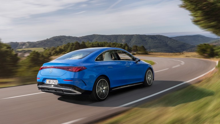 
			Heckansicht eines blauen CLA mit EQ Technologie, der ber eine Strae inmitten einer grnen und bergigen Landschaft fhrt.
		