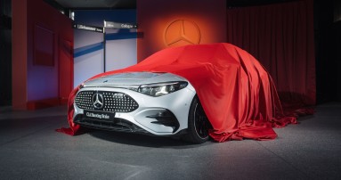 
						  Ein weier CLA Shooting Brake mit EQ Technologie steht in einer Art Studio und ist zur Hlfte von einem roten Tuch bedeckt.
						  