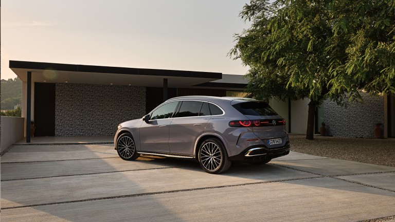 
			Ein Mercedes-Benz GLC in lavender silver ist von hinten zu sehen. Die LED-Heckleuchten leuchten in Sternoptik, im Hintergrund ein modernes Haus mit Baum.
		