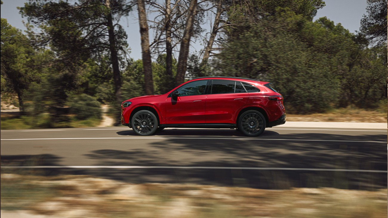 
			Seitenansicht eines Mercedes-Benz GLC in Lack MANUFAKTUR patagonienrot metallic, der auf einer Landstra�e f�hrt, neben der Stra�e befinden sich mehrere B�ume.
		