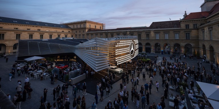 
				Messestand mit illuminiertem Mercedes-Benz Stern im Apothekenhof der M�nchner Residenz. Rund um den Stand stehen zahlreiche Besucherinnen und Besucher.
				