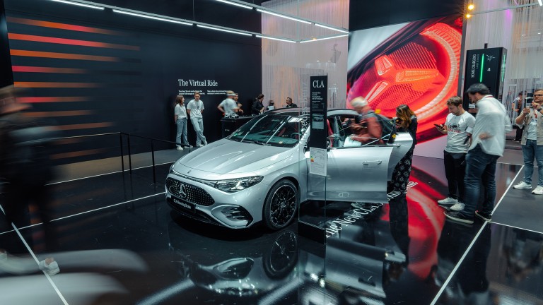 
			Silberner Mercedes-Benz CLA Shooting Brake im Vordergrund. Die T�ren sind ge�ffnet, mehrere Personen rechts und links betrachten das Fahrzeug.
		