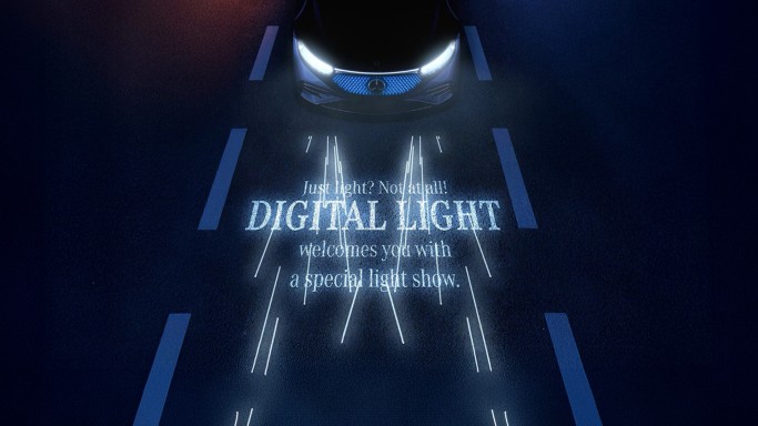 
				Die Scheinwerfer eines Mercedes-Benz projizieren mit DIGITAL LIGHT einen Schriftzug auf die Stra�e: &bdquo;Just light? Not at all! DIGITAL LIGHT welcomes you with a special light show.&ldquo;
				