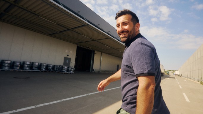 
				Ali Tas, Produktmanager Sonderausstattung &bdquo;Winterkomplettr�der ab Werk 8-fach Bereifung&ldquo; bei Mercedes-Benz Customer Solutions GmbH, l�uft drau�en vor dem R�derlager in Zwickau und blickt l�chelnd in die Kamera.
				