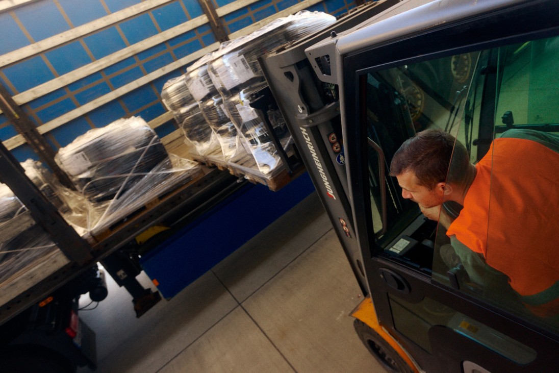 
			Ein Gabelstaplerfahrer in Warnweste l�dt verpackte Reifenpaletten auf einen LKW.
		