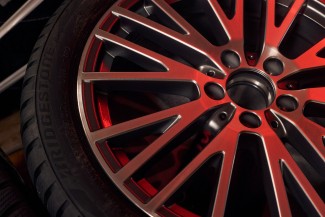 
Ein Winterreifen in Nahaufnahme mit Fokus auf die Felgen, auf die ein rtliches Licht scheint.
