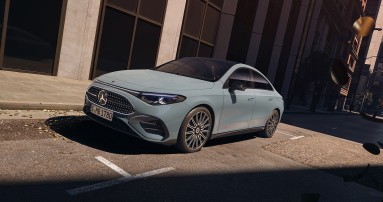 
					  Der CLA Hybrid in aquamint in einer Aufnahme von schrg vorne auf dem sonnigen Parkplatz einer Strae stehend.
					  