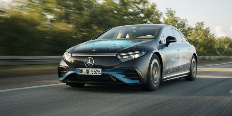 
				Vorderansicht des EQS, der auf einer Landstrae mit Bumen am Rand fhrt.
				