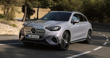 
						  Der neue vollelektrische Mercedes-Benz GLC fhrt auf einer kurvenreichen Landstrae durch eine von Bumen gesumte Landschaft.
						  