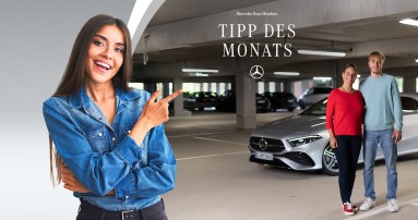 
						  Eine brnette Frau deutet mit dem Zeigefinger auf ein Bild von Susanne Gutmann von Mercedes-Benz Members und ihrem Sohn, die Arm in Arm in einer Tiefgarage vor einer silbernen A-Klasse stehen. In der oberen Hlfte des Bilds steht „Mercedes-Benz Members Tipp des Monats“, darunter ist der Mercedes-Stern abgebildet.
						  