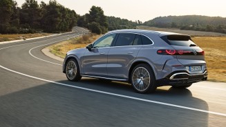 
Heckansicht eines Mercedes-Benz GLC in lavender silver, der auf einer Landstra�e durch eine sommerliche Landschaft f�hrt.
