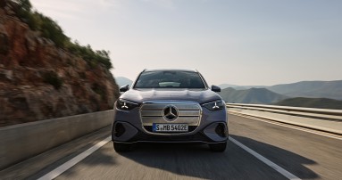 
					   Ein neues Modell des Mercedes-Benz GLC in lavender silver fhrt auf einer Bergstrae. Das Fahrzeug ist frontal zu sehen, das Tagfahrlicht ist eingeschaltet. Im Hintergrund sind Felsen, Leitplanken und eine hgelige Landschaft unter klarem Himmel erkennbar.
					  