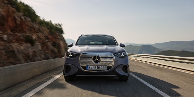 
				 Ein neues Modell des Mercedes-Benz GLC in lavender silver f�hrt auf einer Bergstra�e. Das Fahrzeug ist frontal zu sehen, das Tagfahrlicht ist eingeschaltet. Im Hintergrund sind Felsen, Leitplanken und eine h�gelige Landschaft unter klarem Himmel erkennbar.
				