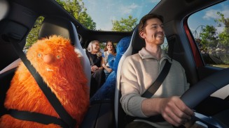 
Innenraum eines Mercedes-Benz GLB mit Panoramadach: Ein Mann sitzt am Steuer, neben ihm auf dem Beifahrersitz angeschnallt ein gro�es orangefarbenes Kuscheltier. Auf der R�ckbank sitzen eine Frau und ein M�dchen. Durch das Glasdach ist der Himmel zu sehen.

