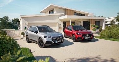 
					  Zwei Mercedes-Benz GLB stehen vor einem modernen Einfamilienhaus: links der vollelektrische GLB in Hightechsilber metallic an einer Wallbox, rechts der hybride GLB in MANUFAKTUR patagonienrot metallic.
					  