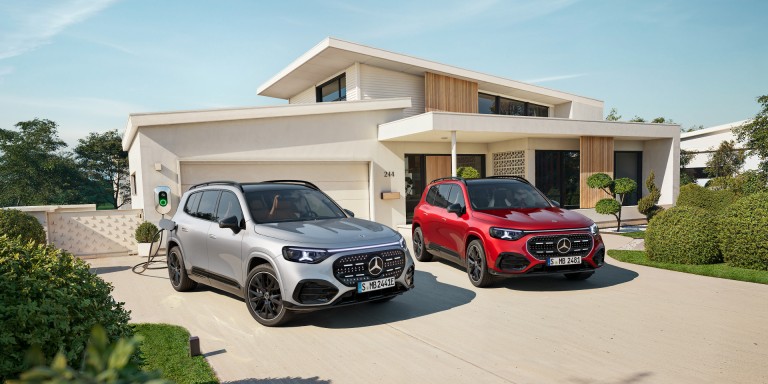 
				Zwei Mercedes-Benz GLB stehen vor einem modernen Einfamilienhaus: links der vollelektrische GLB in Hightechsilber metallic an einer Wallbox, rechts der hybride GLB in MANUFAKTUR patagonienrot metallic.
				