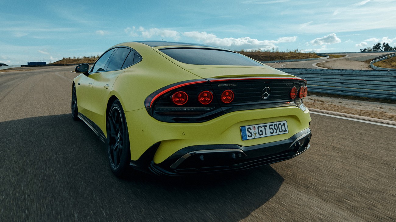 
			Heckansicht des Mercedes-AMG GT 63 4-T�rer Coup� in der Farbe MANUFAKTUR solarbeamyellow uni auf einer kurvenreichen Rennstrecke. Die durchgehende Lichtsignatur und die runden R�ckleuchten pr�gen das Fahrzeugdesign.
		