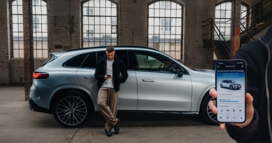 
					  Christopher Hartung von Mercedes-Benz lehnt an einem silbernen Mercedes-Benz Fahrzeug und schaut auf sein Handy in seiner rechten Hand, am rechten Bildschirmrand ist ein Handy eingeblendet, auf dem die Mercedes-Benz App ge�ffnet ist.
					  