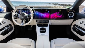 
Blick in den Innenraum des neuen elektrischen Mercedes-Benz CLA Shooting Brake mit EQ Technologie mit hellem ARTICO Interieur in ivory beige. Der MBUX Superscreen erstreckt sich �ber die gesamte Instrumententafel, durch die Frontscheibe sind Meer und felsige K�ste zu sehen.
