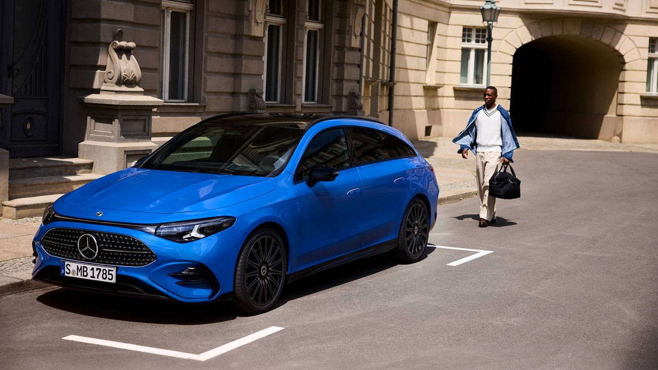 
			Ein Mann mit einer blauen Jacke und einer Reisetasche in der linken Hand l�uft auf einen Mercedes-Benz CLA Shooting Brake in der Farbe klarblau metallic zu, der in einer urbanen Umgebung auf einem Parkplatz parkt.
		
