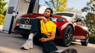 
Ein Mann im gelbem T-Shirt und dunklen Jeans sitzt vorne an der linken Front eines CLA in MANUFAKTUR patagonienrot metallic auf dem Boden und tr�gt Kopfh�rer, sein rechtes Bein ist aufgestellt und sein rechter Arm auf dem Knie abgelegt.
