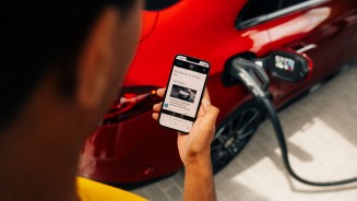 
Ein Mann h�lt ein Smartphone in der Hand, auf dem ein Mercedes-Benz Members Artikel zu sehen ist. Im Hintergrund erkennt man unscharf einen CLA in MANUFAKTUR patagonienrot metallic, an dessen Ladeb�chse ein Ladekabel angeschlossen ist.
