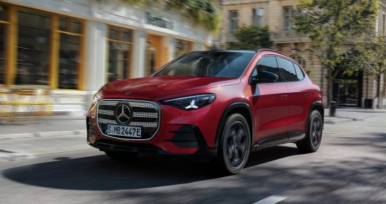 
					  Der neue GLA von Mercedes-Benz in MANUFAKTUR patagonienrot metallic f�hrt durch eine urbane Landschaft, im Hintergrund sind unscharf Geb�ude zu erkennen.
					  