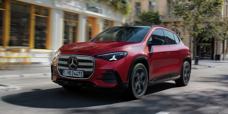 
				Der neue GLA von Mercedes-Benz in MANUFAKTUR patagonienrot metallic f�hrt durch eine urbane Landschaft, im Hintergrund sind unscharf Geb�ude zu erkennen.
				