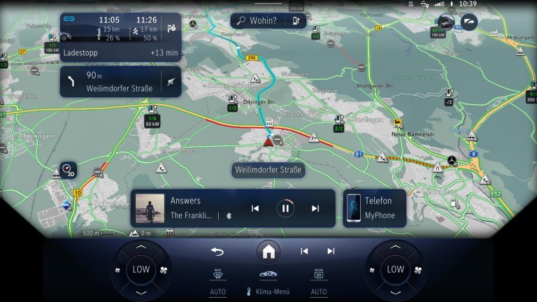 
			Karte im Navigationssystem des MBUX, auf der eine Route, Verkehrsinformationen und ein Mediaplayer-Interface angezeigt werden.
		
