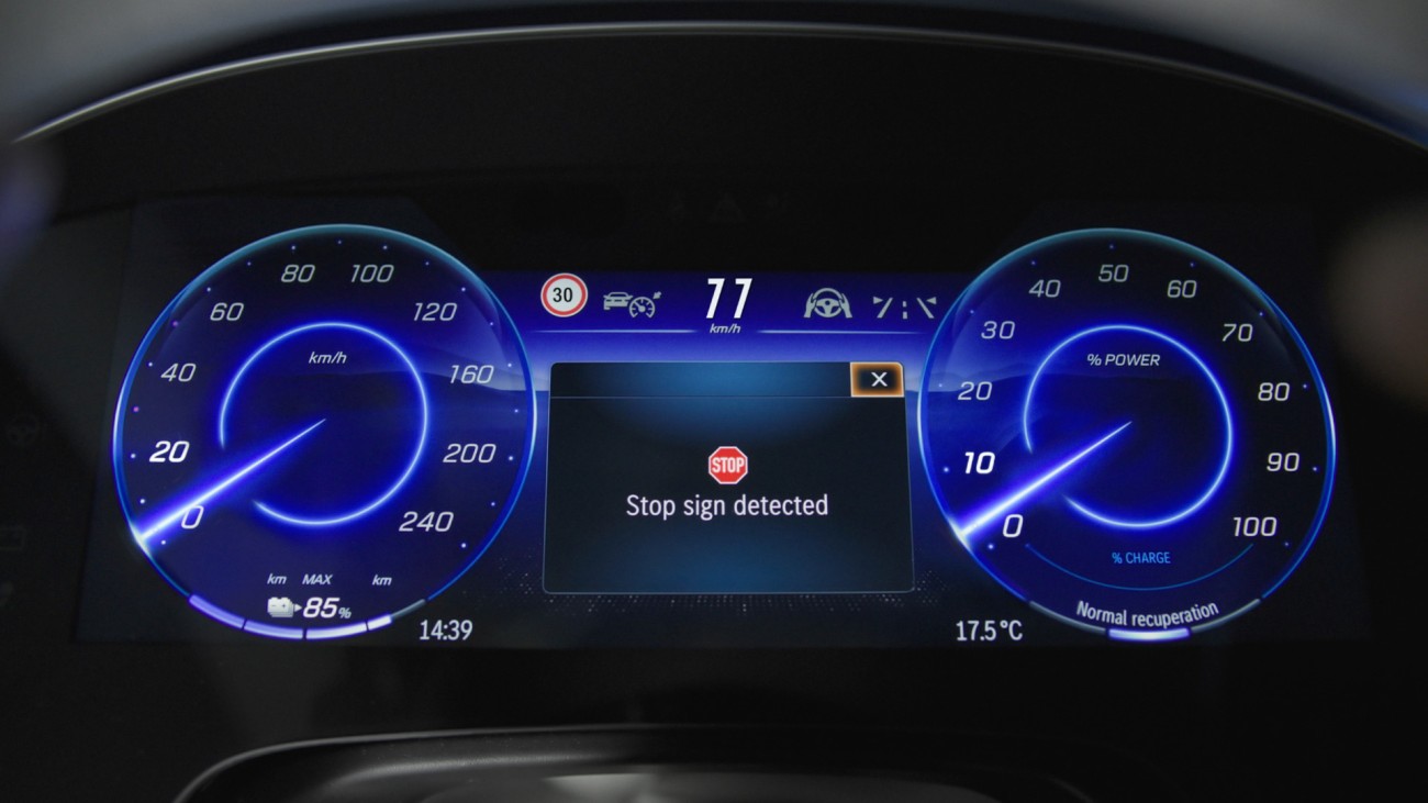 
			Digitales Fahrerdisplay mit blau beleuchteten Instrumenten und der Anzeige &bdquo;Stop sign detected&ldquo; in der Bildschirmmitte.
		