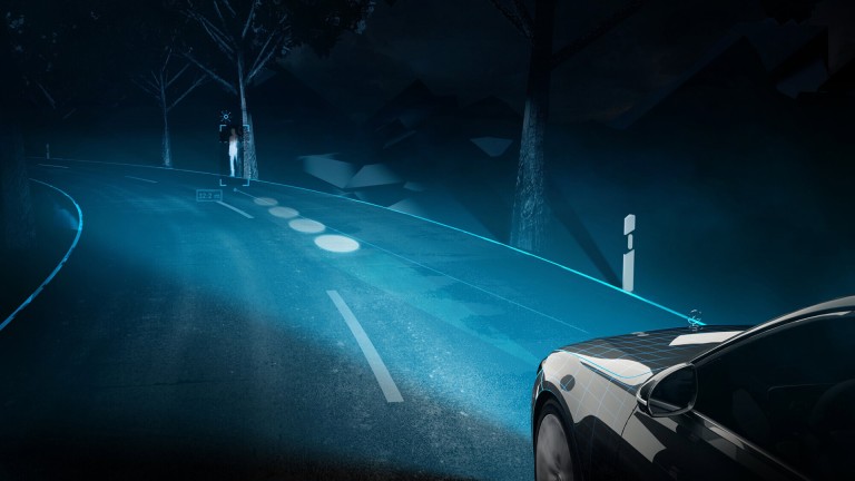
			Blick auf eine Fahrbahn bei Nacht, auf der ein Mercedes-Benz Fahrzeug f�hrt, das das optionale Digitale Extra DIGITAL LIGHT mit Projektionsfunktion nutzt. Auf der Fahrbahn vor dem Fahrzeug registriert das System einen Fu�g�nger und weist den Fahrenden mit Projektionen darauf hin.
		